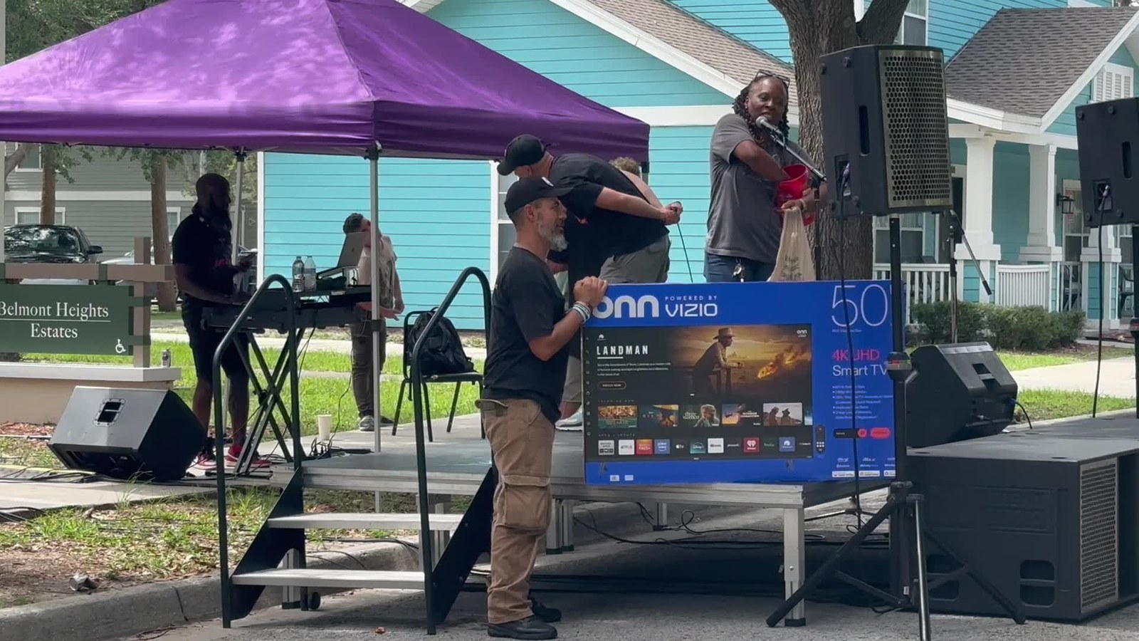 Volunteers and residents gathered under a tent at a Belmont Heights Estates community event