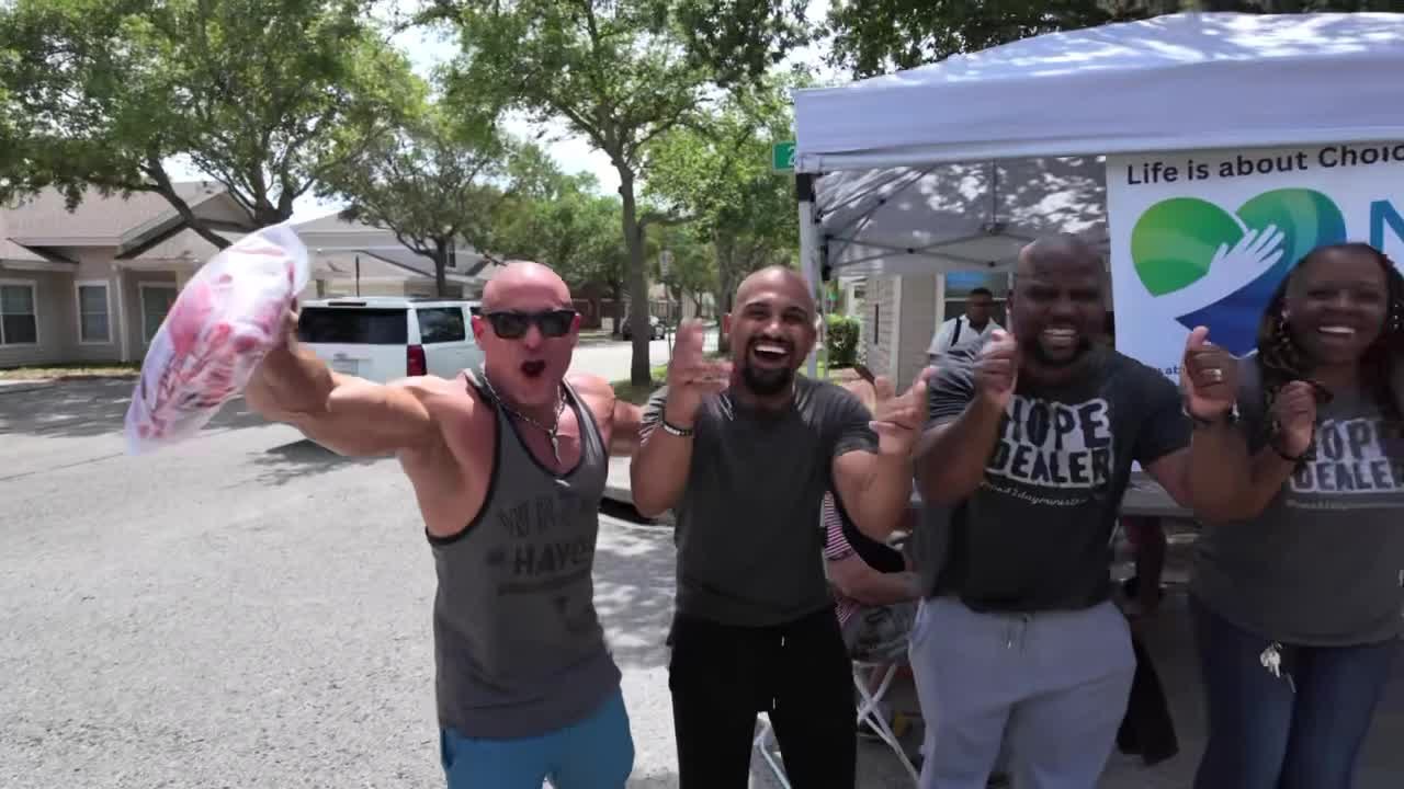 Volunteers celebrating outside a NuHealth Reach health outreach tent in a residential neighborhood